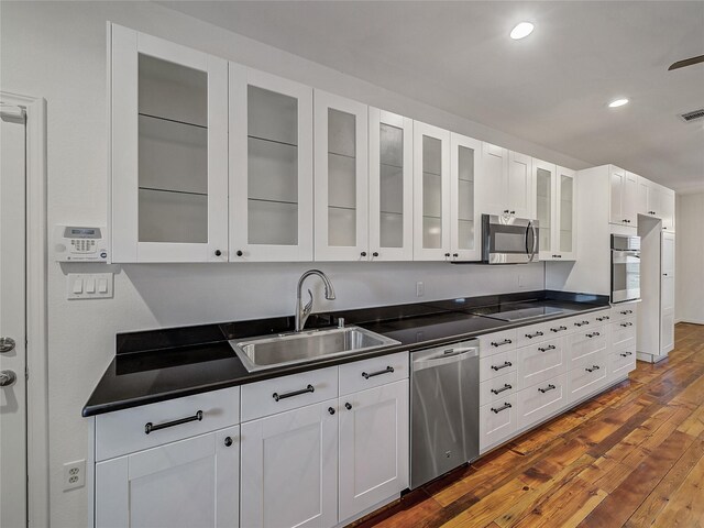 kitchen with sink, dark hardwood / wood-style flooring, stainless steel appliances, and white cabinetry