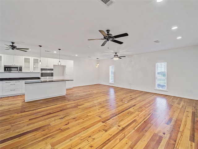 unfurnished living room with light hardwood / wood-style flooring and ceiling fan