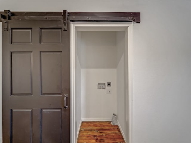 laundry room featuring a barn door, hookup for an electric dryer, washer hookup, and hardwood / wood-style floors