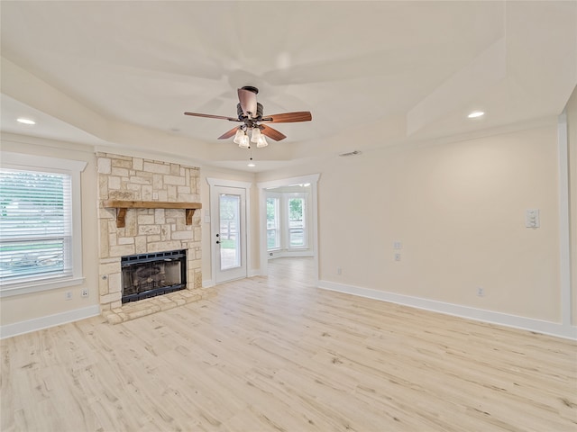 unfurnished living room featuring light hardwood / wood-style floors, a fireplace, and ceiling fan