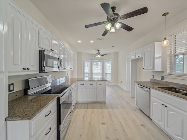 kitchen featuring light hardwood / wood-style flooring, a wealth of natural light, white cabinetry, and stainless steel appliances