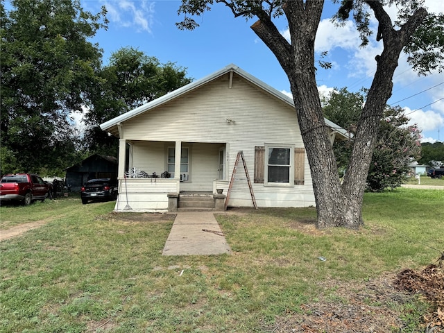 bungalow featuring a porch and a front lawn