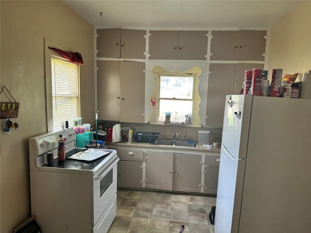 kitchen featuring sink, light tile patterned floors, and white appliances