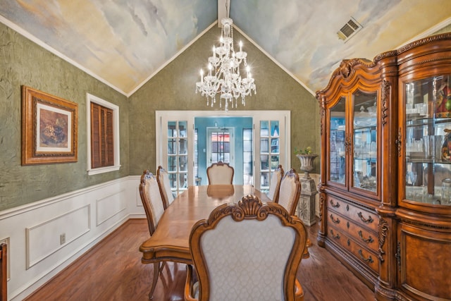 dining space featuring hardwood / wood-style flooring, ornamental molding, lofted ceiling, and a notable chandelier