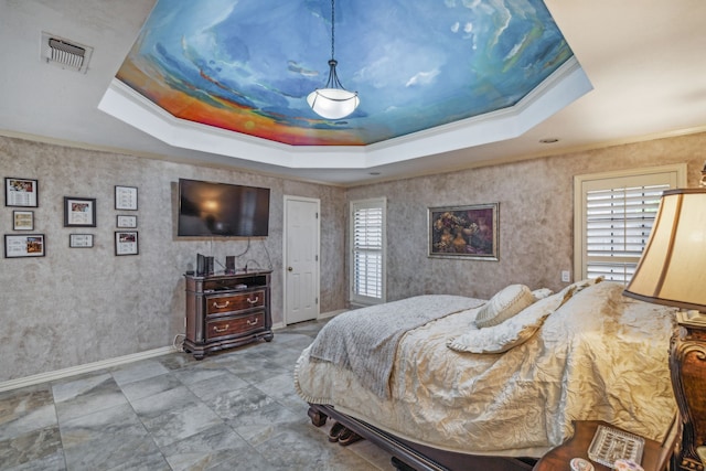 bedroom with ornamental molding and a tray ceiling