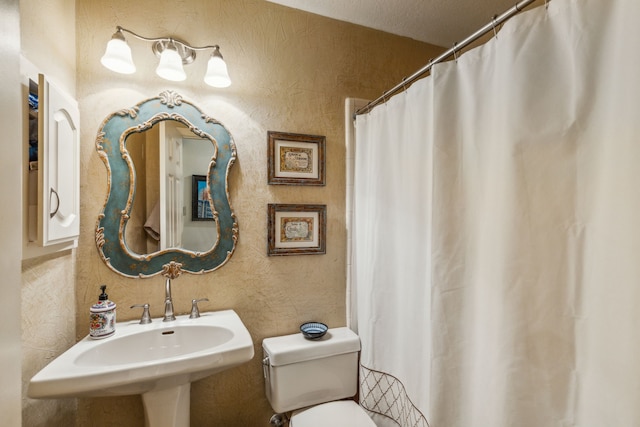 bathroom featuring sink, a textured ceiling, and toilet