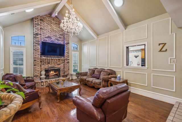 living room with a notable chandelier, a fireplace, high vaulted ceiling, and beamed ceiling