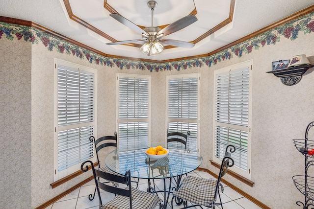 dining area featuring crown molding, ceiling fan, a raised ceiling, and light tile patterned floors