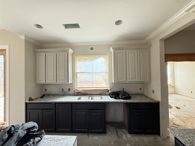 kitchen featuring ornamental molding, white cabinets, light stone counters, and sink