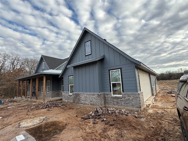 view of side of home with a garage and a porch