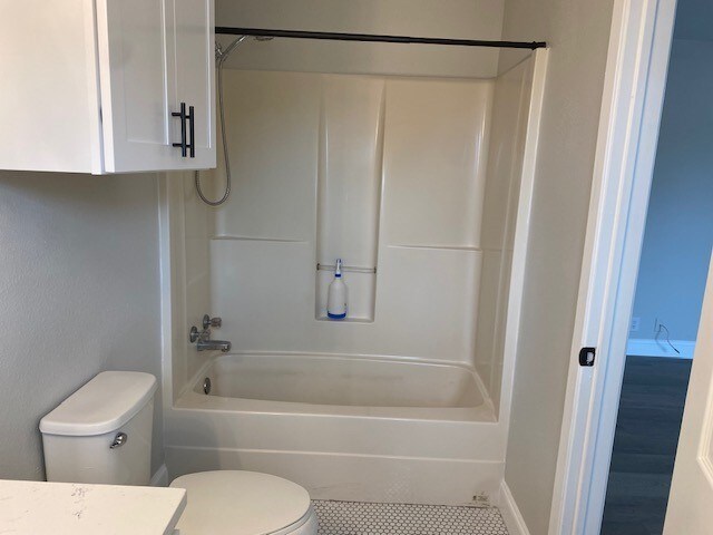 full bathroom featuring vanity, tile patterned flooring,  shower combination, and toilet