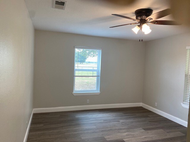 spare room featuring dark hardwood / wood-style flooring and ceiling fan