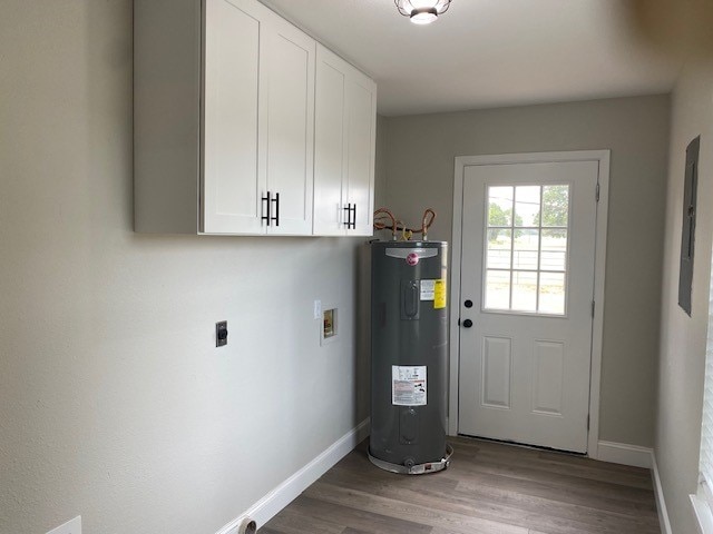 interior space with wood finished floors, electric water heater, and baseboards