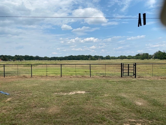 view of yard featuring fence and a rural view