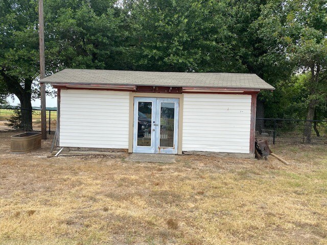 view of outbuilding featuring french doors and a lawn