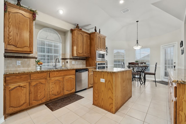 kitchen featuring sink, a center island, appliances with stainless steel finishes, and decorative backsplash