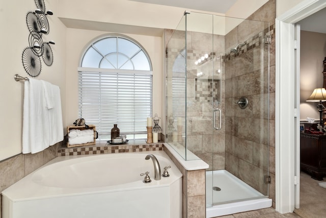 bathroom featuring shower with separate bathtub