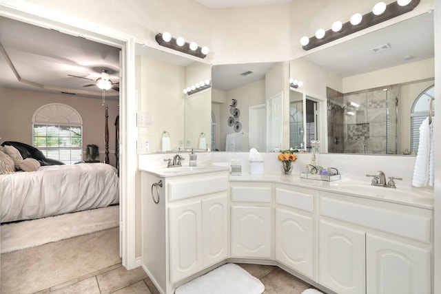 bathroom with dual vanity, a tile shower, tile patterned floors, and ceiling fan