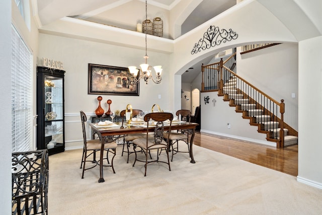 dining space featuring a notable chandelier, wood-type flooring, and high vaulted ceiling