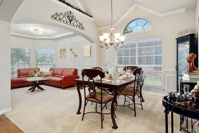 dining area with an inviting chandelier, light colored carpet, and crown molding