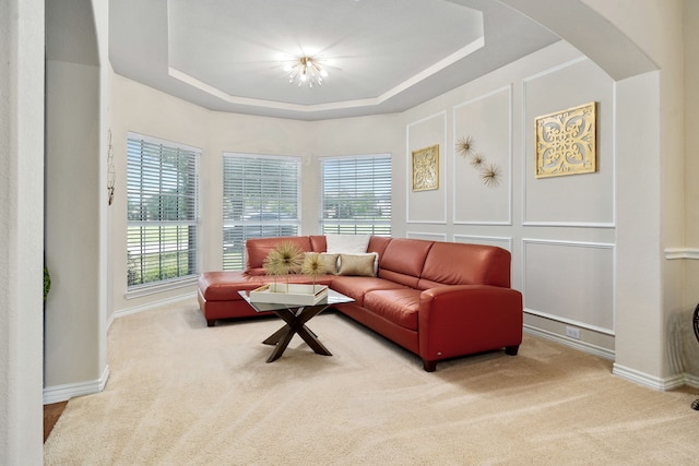 carpeted living room with a raised ceiling