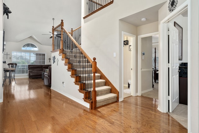 staircase with carpet floors, ceiling fan, and lofted ceiling