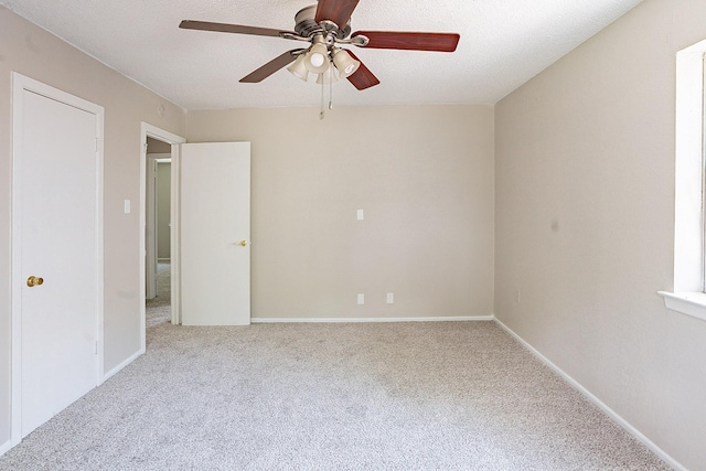 empty room featuring ceiling fan and light colored carpet