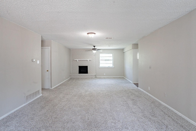 unfurnished living room featuring ceiling fan, a fireplace, light carpet, and a textured ceiling