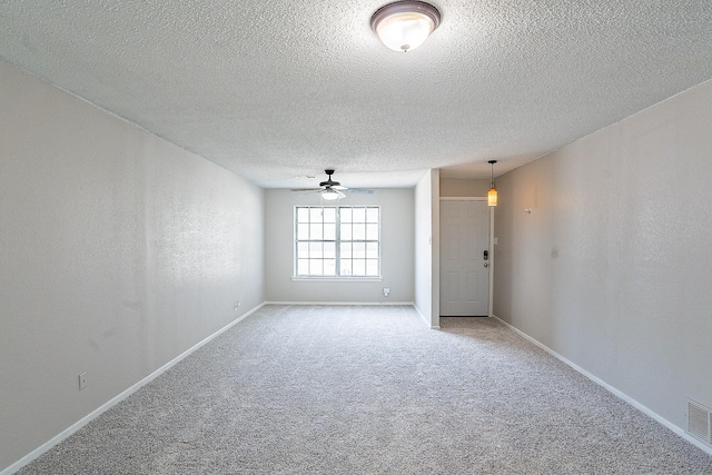 empty room with carpet flooring, a textured ceiling, and ceiling fan