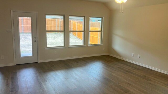 unfurnished room featuring dark hardwood / wood-style floors and lofted ceiling