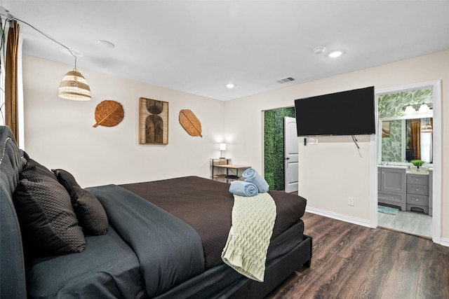 bedroom featuring ensuite bathroom and dark hardwood / wood-style floors