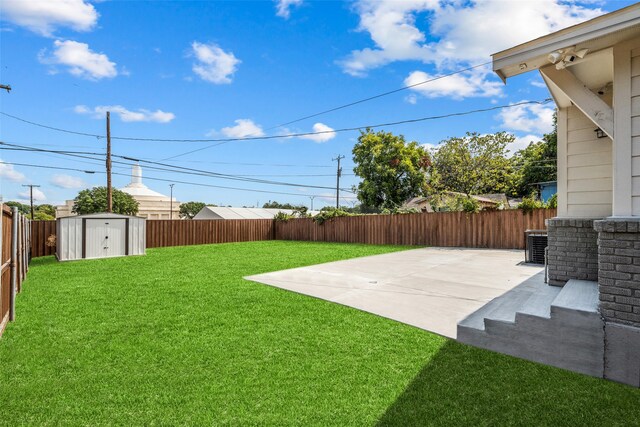 view of yard with a patio area, a storage unit, and central AC