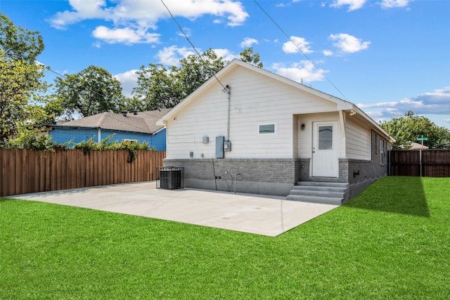 rear view of property featuring a yard, a patio, and central air condition unit