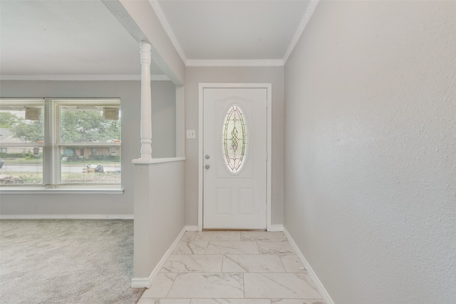 foyer entrance with ornamental molding, light carpet, and ornate columns