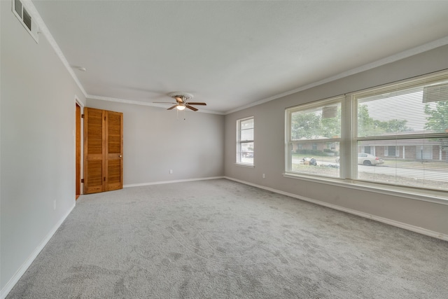 spare room with ornamental molding, carpet floors, and ceiling fan