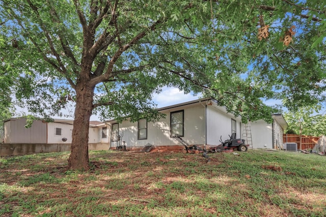 view of front of home featuring central AC unit and a front lawn