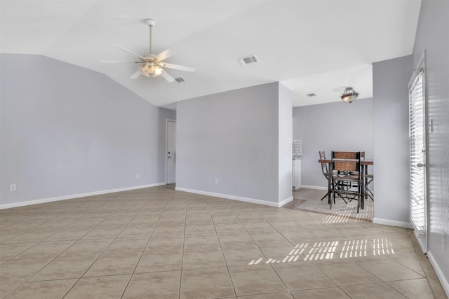 tiled empty room featuring ceiling fan, a healthy amount of sunlight, and vaulted ceiling