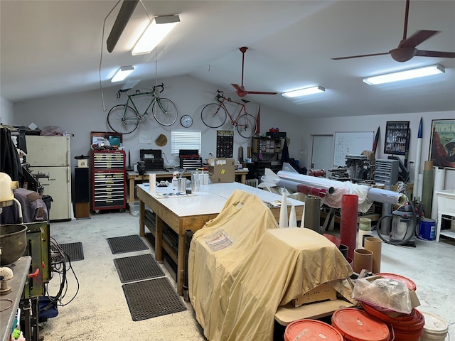 garage with ceiling fan, white refrigerator, and a workshop area