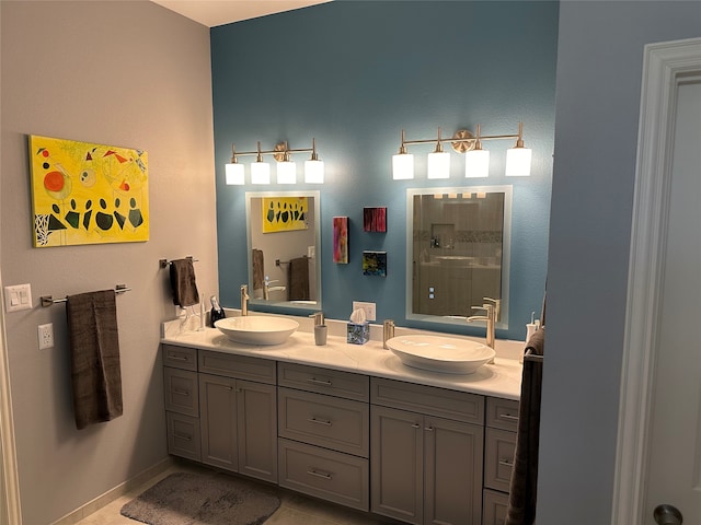 bathroom featuring a shower, dual vanity, and tile patterned flooring