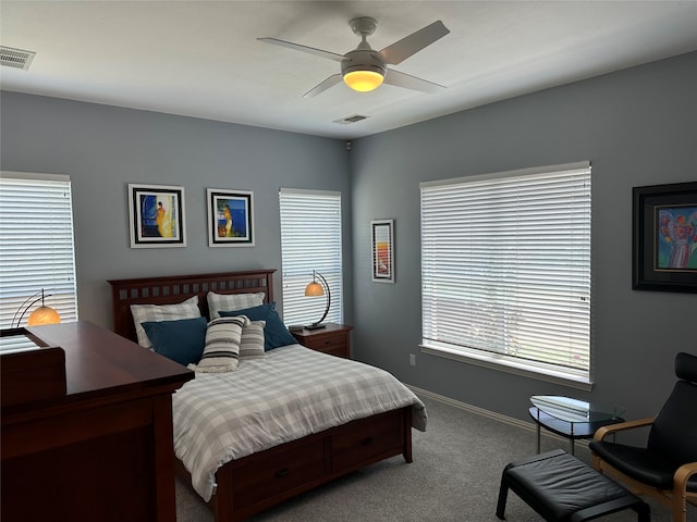 carpeted bedroom with ceiling fan and multiple windows