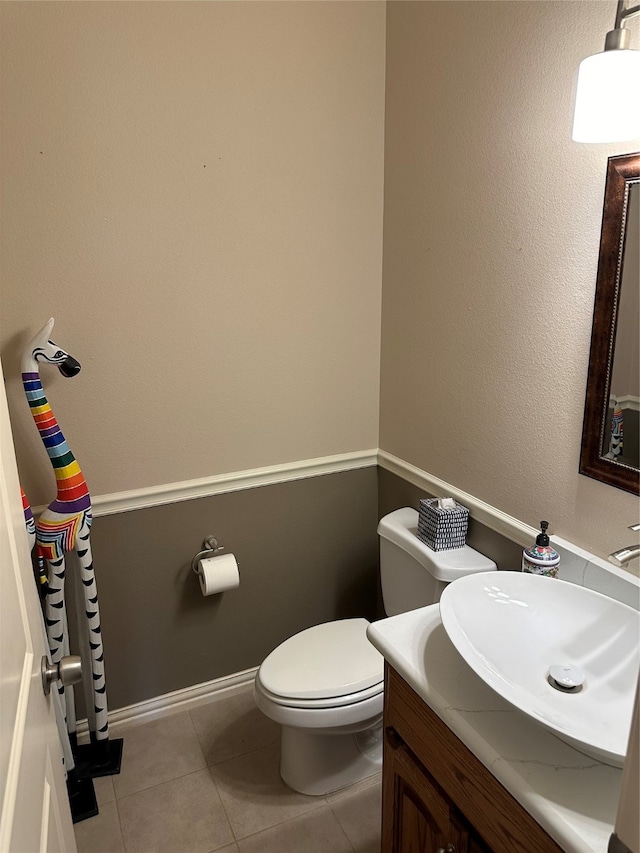 bathroom with toilet, tile patterned floors, and vanity