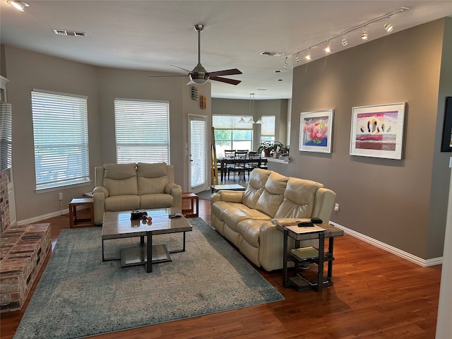 living room with dark wood-type flooring, track lighting, and ceiling fan