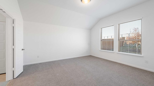 bonus room with light colored carpet and lofted ceiling