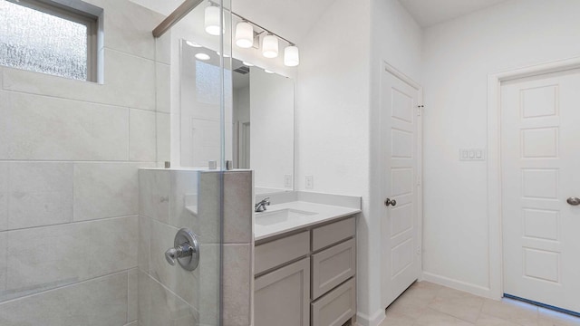 bathroom featuring tile patterned flooring, vanity, and tiled shower