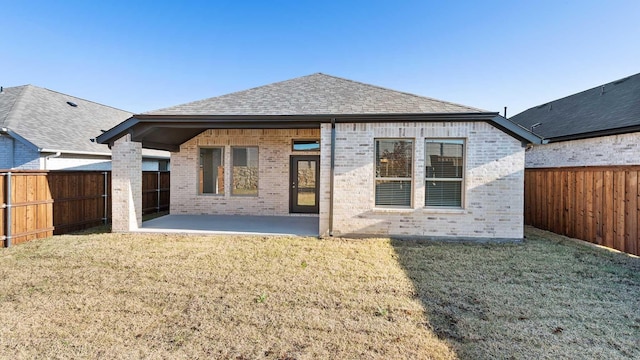 rear view of property featuring a yard and a patio area