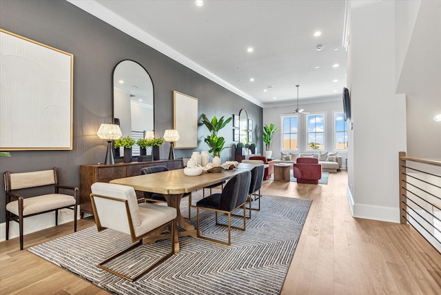 dining area with light hardwood / wood-style flooring and ornamental molding