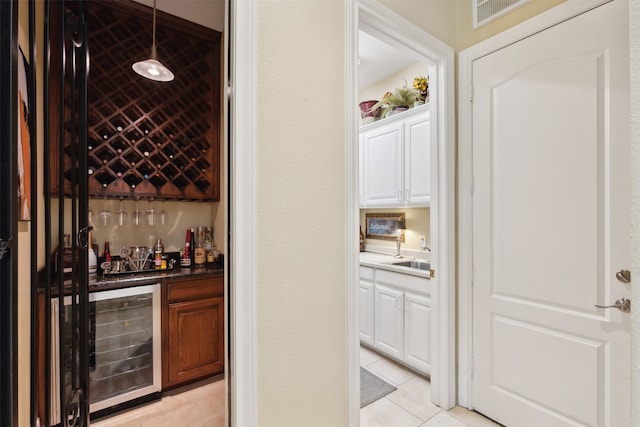 wine room featuring sink, light tile patterned flooring, and beverage cooler