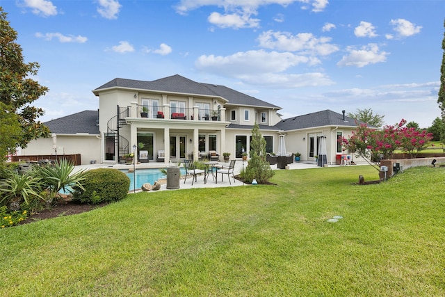 back of house featuring a balcony, a patio, a yard, and french doors