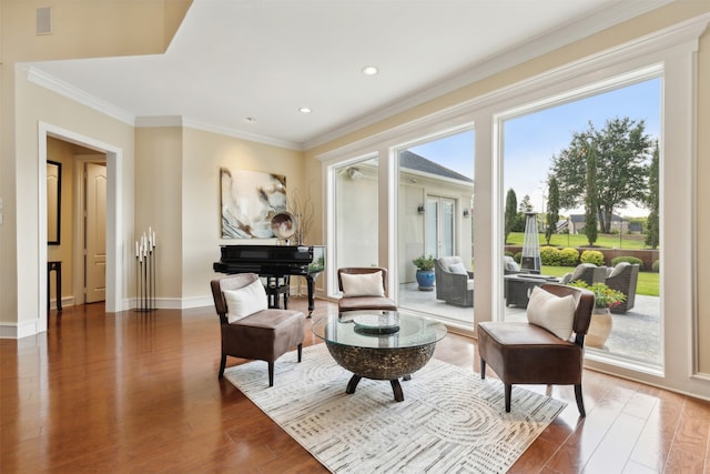 living area featuring plenty of natural light, ornamental molding, and hardwood / wood-style floors