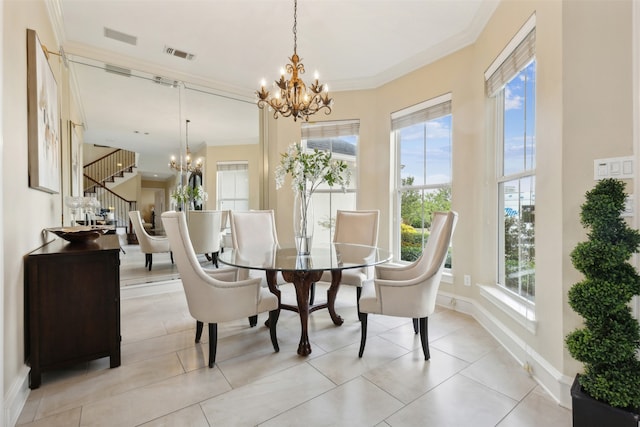 tiled dining area featuring ornamental molding and an inviting chandelier